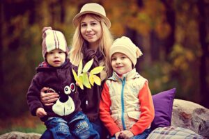 mamma con bambini sulle gambe in un parco